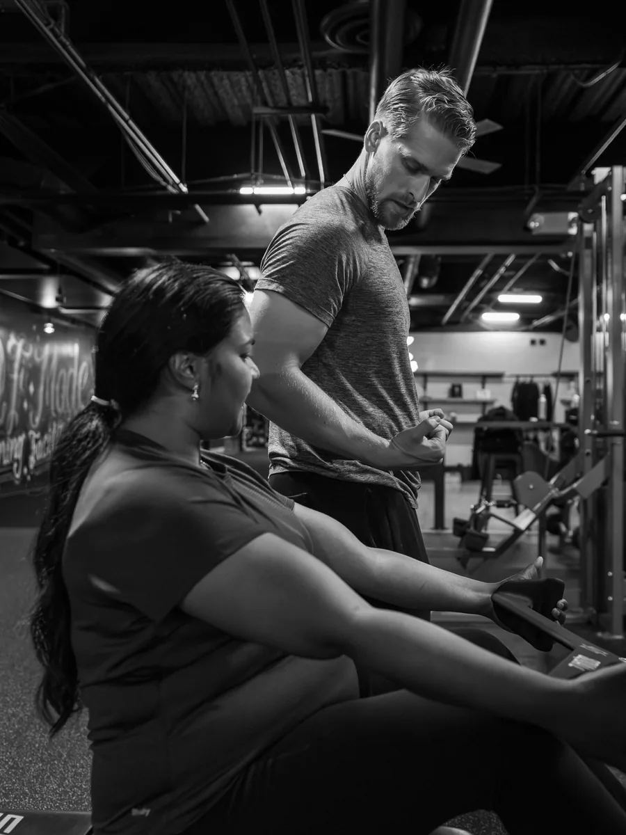 Chance Dyck coaching a client on a cable machine during a training session.